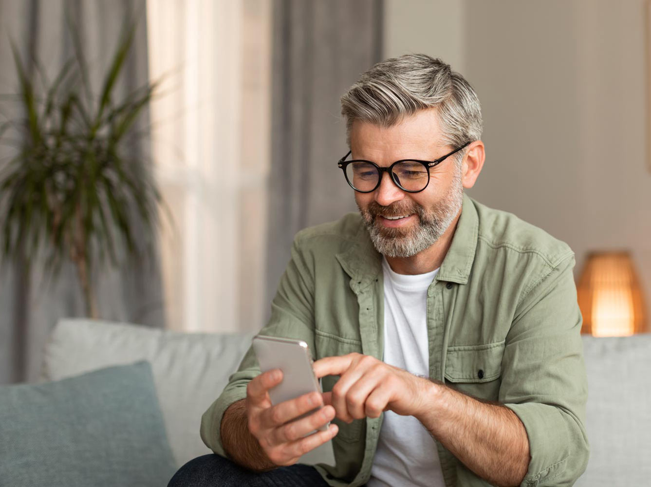 Middle aged man using his phone and smiling